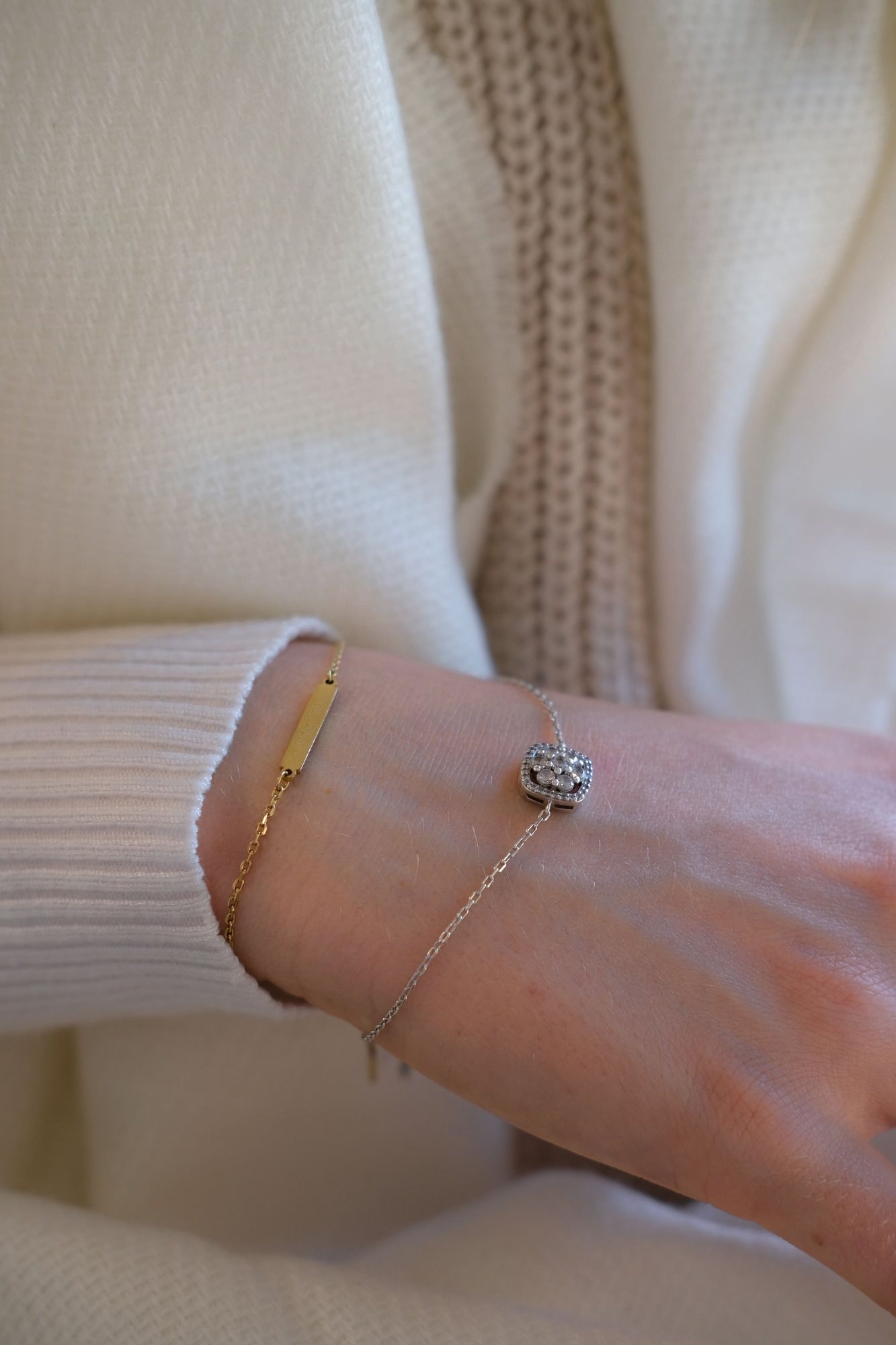 Bracciale sottile in oro al polso, con un maglione chiaro